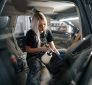 Woman detailing car seatbelt. How often should you detail your car?